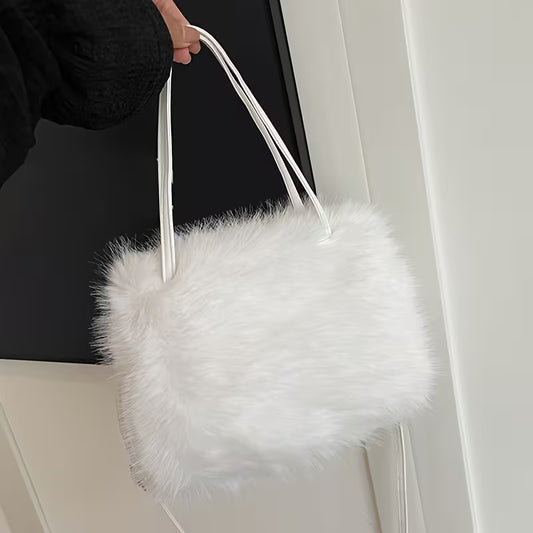 White fluffy handbag held by a person against a neutral background